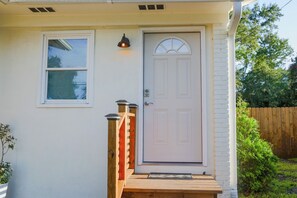 A house with a white door, a small window, and a wooden porch.