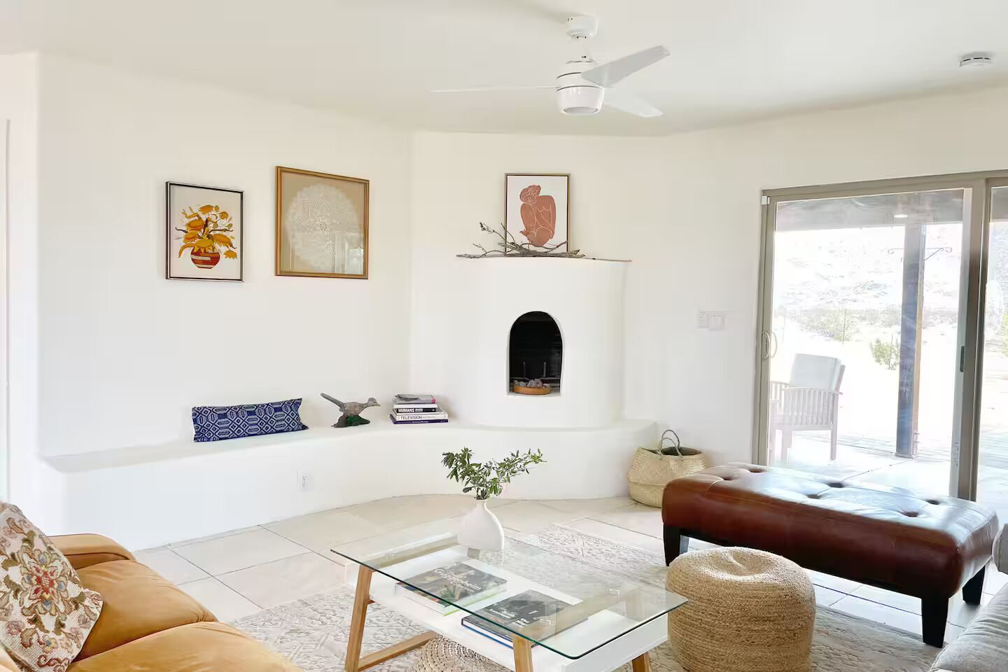 Ein Wohnzimmer mit Sofa, Couchtisch, Kamin und Blick durch eine Glasschiebetür.