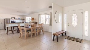 Una cocina amplia con comedor, una banca y una puerta con paneles de vidrio decorativos.