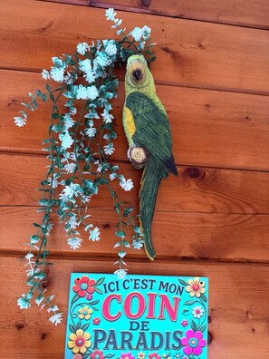 A wooden surface with a decorative bird and a colorful sign.