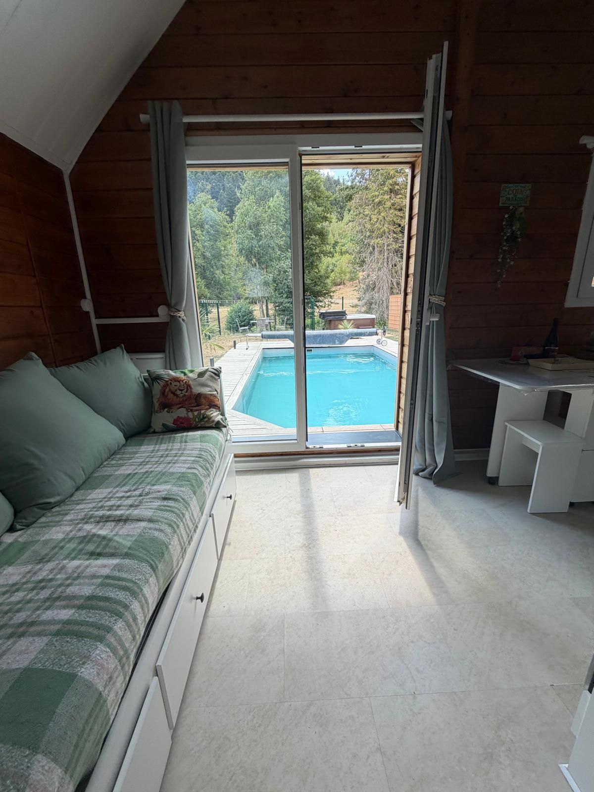 Ein Zimmer mit einem Bett, einem Schreibtisch und Blick auf einen Swimmingpool.