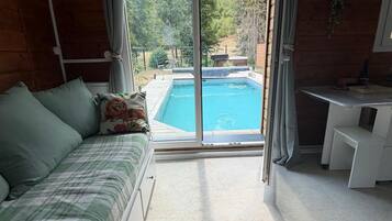 Ein Zimmer mit einem Bett, einem Schreibtisch und Blick auf einen Swimmingpool.