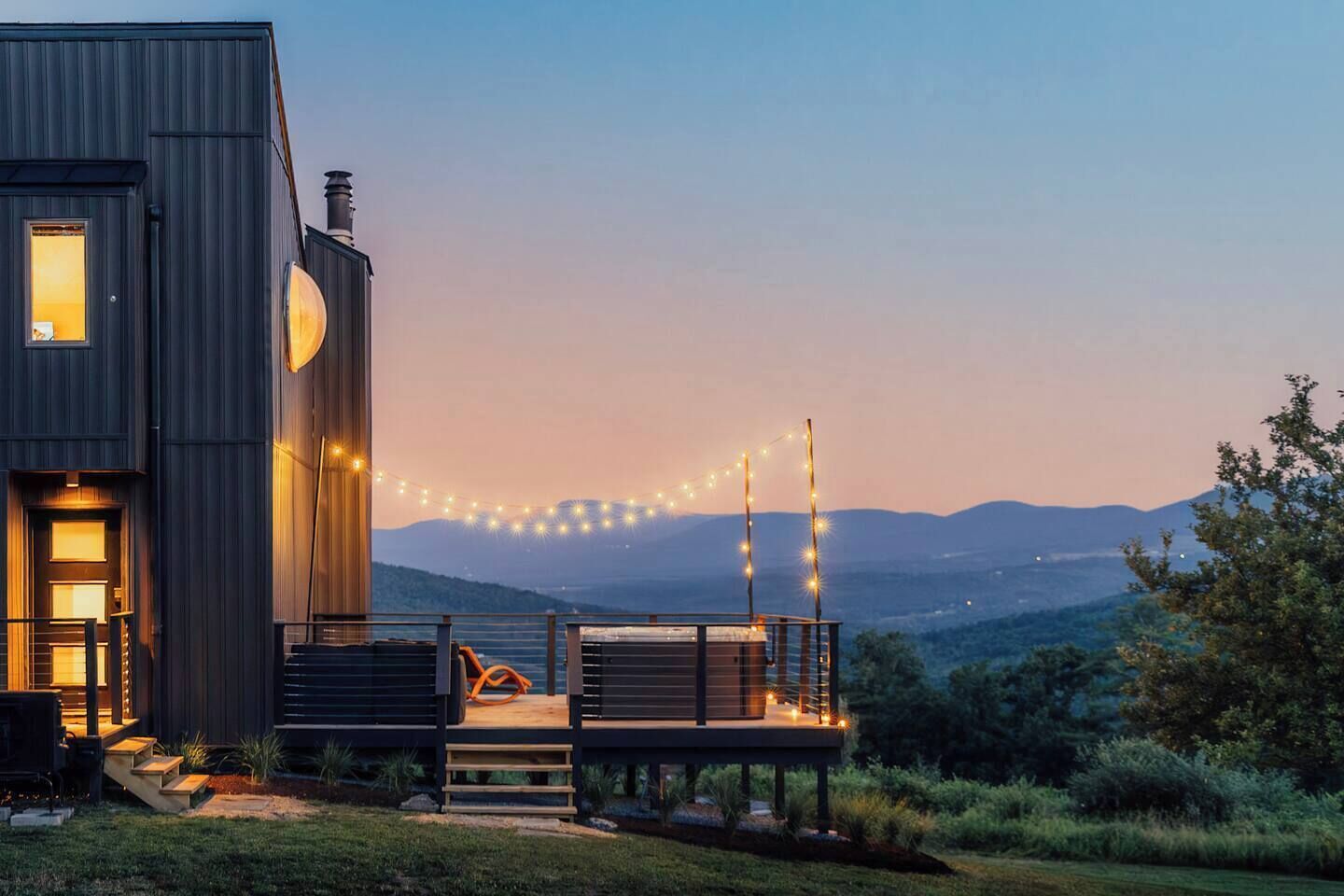 Una casa moderna con una terrazza affacciata su un paesaggio montuoso.