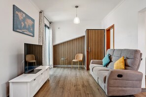 Una sala de estar moderna con un sofá, un televisor y un mapa del mundo en la pared.