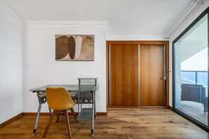 A dining area with a glass table, a chair, and a wooden floor. - Villa Brava Sunset by Homie (Ribeira Brava)