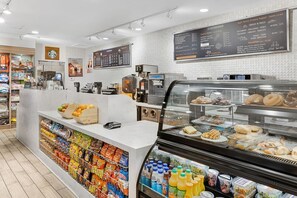 A bakery counter with pastries, a refrigerated display case with drinks, and a coffee machine. - Coachella Music Festival - Fabulous apartment in Palm Desert, Shuttle to Grounds (Palm Desert)
