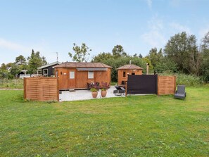 A wooden cabin with a patio area, a covered outdoor seating space, and a fenced garden. - "Ingebore" - 500m from the sea by Interhome (Præstø)