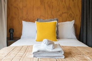A hotel room with a bed, a bedside table, and a lamp. - Sunny Escape Steps from Hagley Park & Hospital (Christchurch)