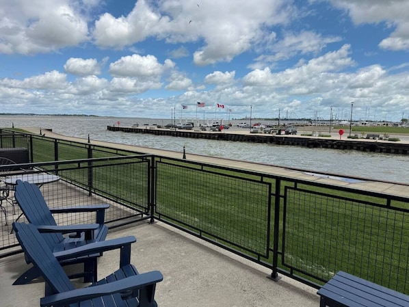 A waterfront patio with seating and a view of the water.
