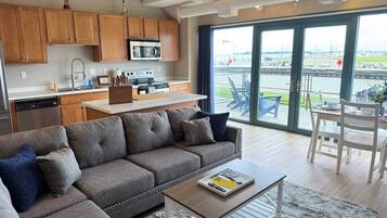 A modern living room with a sofa, coffee table, and a dining area with chairs.