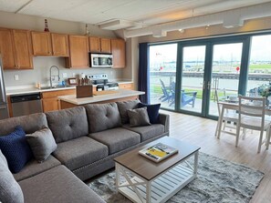 A modern living room with a sofa, coffee table, and a dining area with chairs.