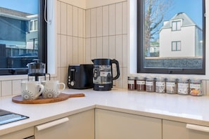 A kitchen with a coffee maker, toaster, and jars of coffee and tea on the counter. - Peaceful Merivale Hideaway - Parkside + Parking (Christchurch)