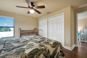 A bedroom with a bed, a ceiling fan, and a view of the outdoors. - Spacious Luxury Home | Beach Access | Resort Living- Sleeps 10 (New Smyrna Beach)