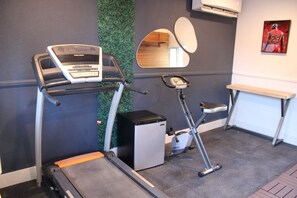 A gym with a treadmill, elliptical, and a mirror. - 5-Bedroom Luxury Home | Jacuzzi/Sauna/BBQ | 15 Min from the Strip (Las Vegas)