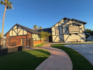 A two-story house with a stone facade, a paved driveway, and a well-maintained lawn. - 5-Bedroom Luxury Home | Jacuzzi/Sauna/BBQ | 15 Min from the Strip (Las Vegas)