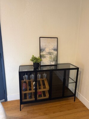 A black glass console table with a potted plant and a framed picture on top. - 5-Bedroom Luxury Home | Jacuzzi/Sauna/BBQ | 15 Min from the Strip (Las Vegas)
