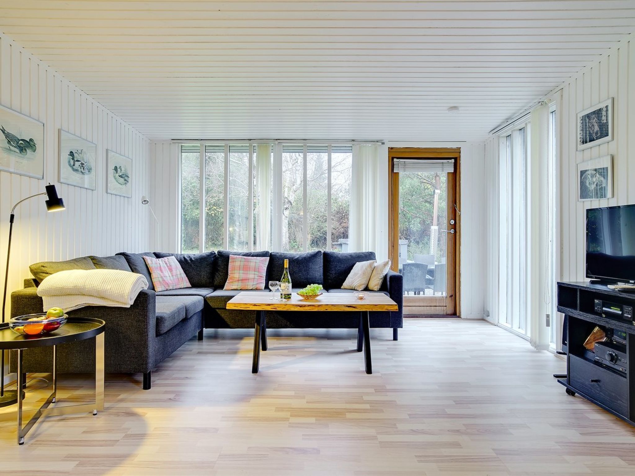 A modern living room with a sectional sofa, a coffee table, and a TV stand.