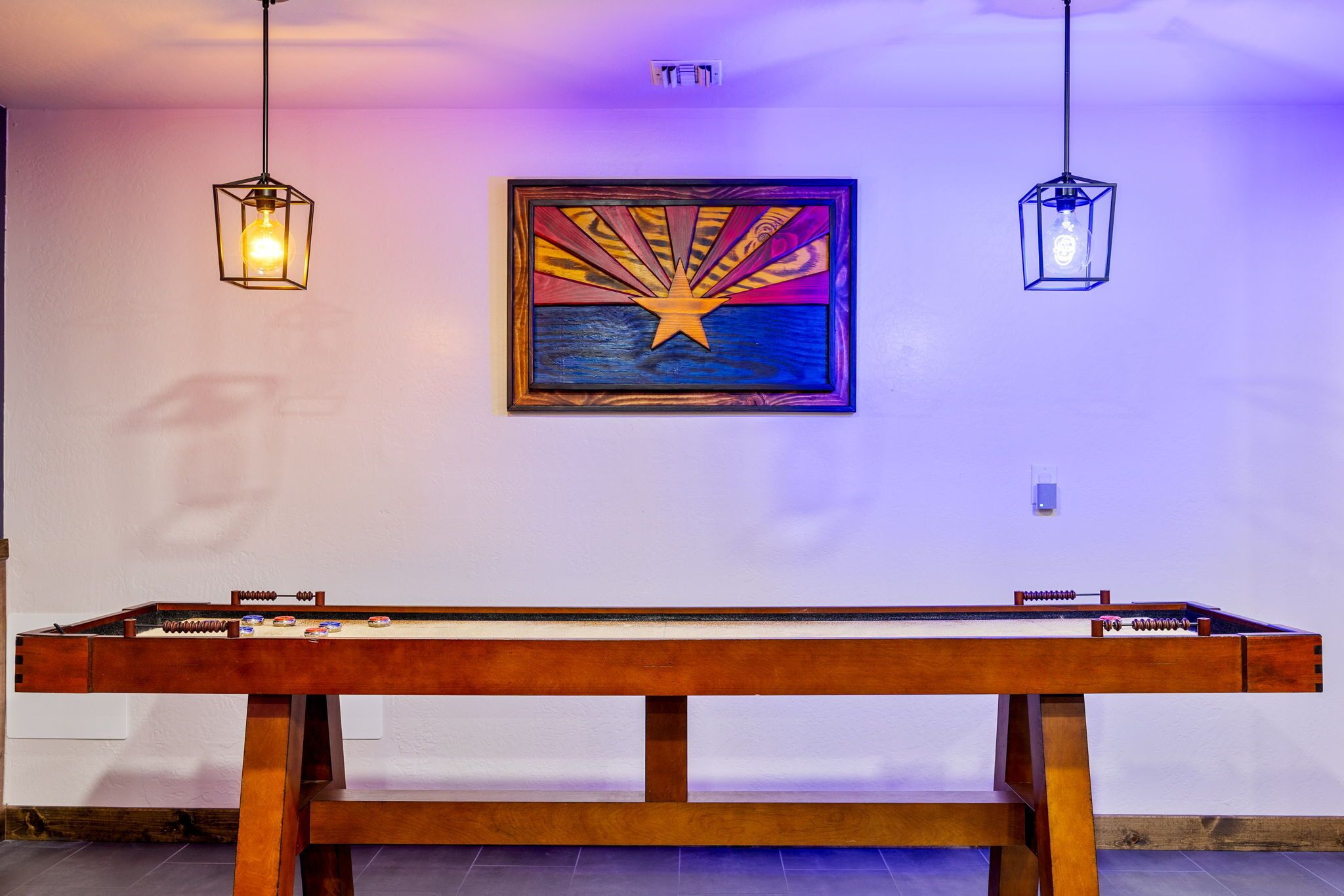 A pool table with a star design on the wall behind it.