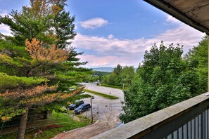 A view of a parking area with cars, surrounded by trees and a clear sky. - Treetop Hearth at Mountain Green | 1BR Balcony Condo | Sleeps 4 (Killington)