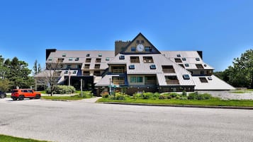 A multi-story hotel with a unique architectural design, featuring a prominent clock tower and multiple balconies.