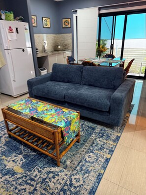 A living room with a sofa, a patterned table, a refrigerator, and a view through a sliding door. - Rivervilla tranquillity by the bay
2 bed unit surrounded by native reserves (Griffin)