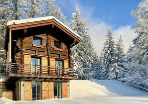 A wooden cabin with a balcony, surrounded by snow-covered trees. - Historic Mazot Retreat by Mrs Miggins – Entire Chalet -Historic Mazot Retreat by Mrs Miggins offers (Lens)
