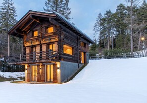 A log cabin with a balcony, surrounded by snow and trees. - Historic Mazot Retreat by Mrs Miggins – Entire Chalet -Historic Mazot Retreat by Mrs Miggins offers (Lens)