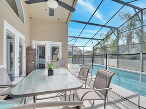 A covered outdoor area with a pool, seating, and a ceiling fan. - Charming 4-bedroom house with AC in welcoming Davenport (Davenport)