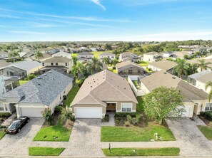 A residential neighborhood with single-family homes, a paved driveway, and a car parked in the driveway. - Charming 4-bedroom house with AC in welcoming Davenport (Davenport)