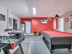 Ein Spielraum mit Kicker, Billardtisch und Dartscheibe.