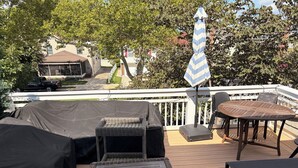 Eine Terrassensitzgruppe im Freien mit Vordach, Tisch und einer Flagge.