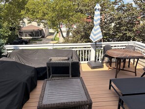 Eine Terrassensitzgruppe im Freien mit Vordach, Tisch und einer Flagge.