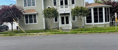 A two-story house with a front porch, a garage, and a driveway.