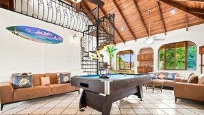 A pool table in a room with a high ceiling, a sofa, and a wall with a mural. - 11 beds, 9 bdrm, 6 bath - Short walk to Bars, Cocal Casino & Beach (Jacó)