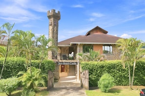 A castle-like building with a stone tower, a covered patio, and lush greenery. - 11 beds, 9 bdrm, 6 bath - Short walk to Bars, Cocal Casino & Beach (Jacó)