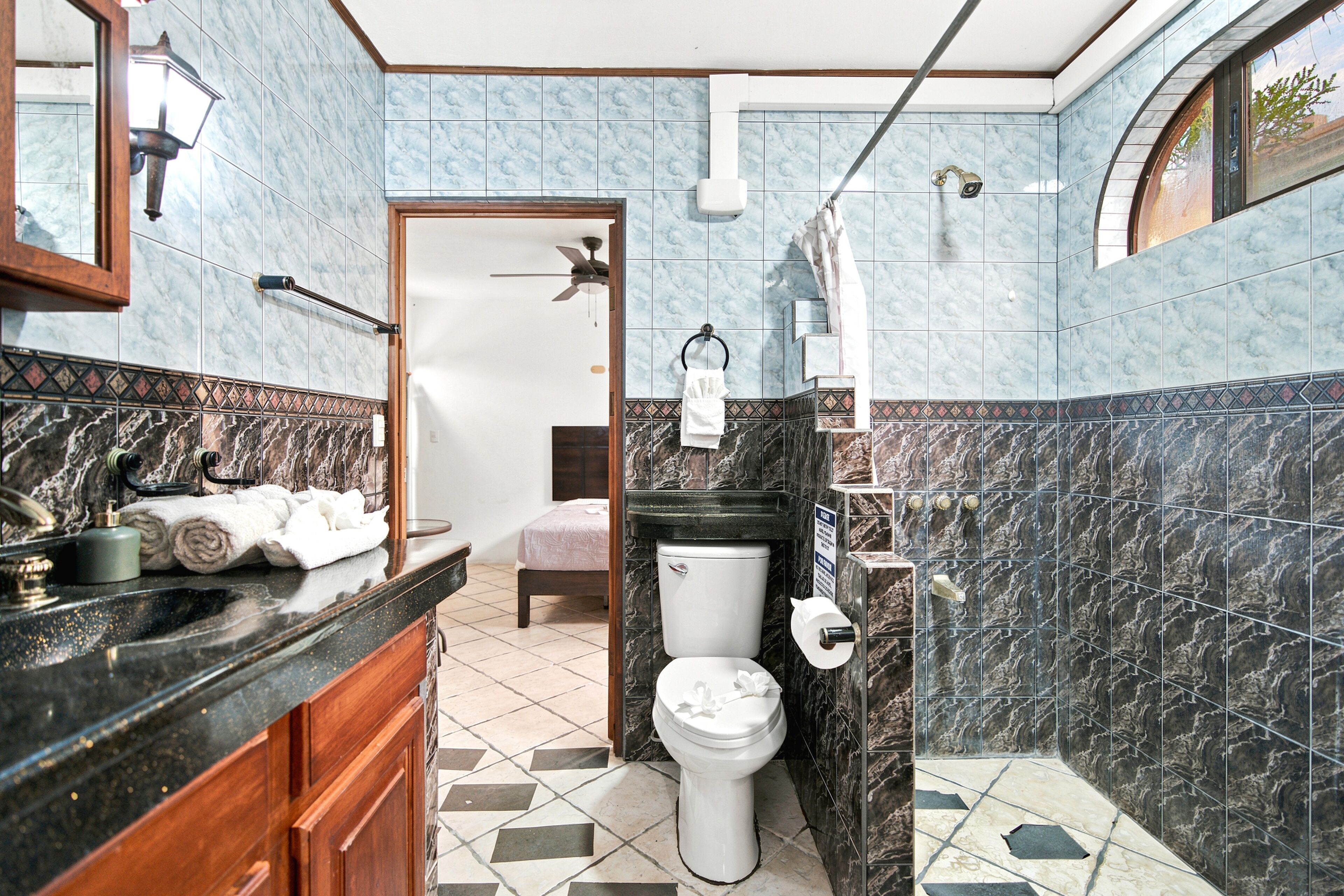 A bathroom with a toilet, sink, and shower area.