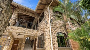A two-story stone building with a balcony, a staircase, and a door. - 11 beds, 9 bdrm, 6 bath - Short walk to Bars, Cocal Casino & Beach (Jacó)