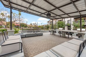An outdoor patio area with seating and a barbecue grill. - Stylish 2BR Getaway Near ASU | Pools, Gym + Parking (Tempe)