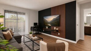 Uma sala de estar moderna com sofá, mesa de centro e televisão fixada na parede, decorada com uma pintura paisagística.