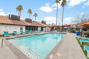 Ein Pool mit Liegestühlen und Palmen.