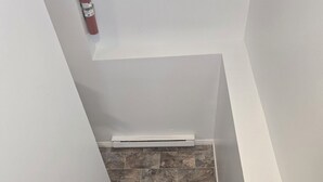 A staircase with stone steps and a fire extinguisher mounted on the wall. - Bright & Cozy One Bedroom Getaway (Grand Falls-Windsor)