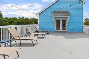 A blue building with a white door and a balcony with lounge chairs. - Walk to the Beach | 5 Minutes to St. Andrews State Park | Easy Access | Updated (Panama City)