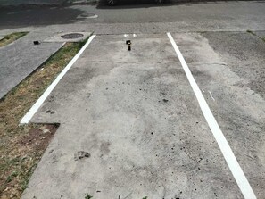 A parking lot with concrete surfaces and white lines marking parking spaces. - Lovely & Cozy 1-Bedroom Loft with AC & Tropical Patio, 5 Minutes from Marigot (Marigot)