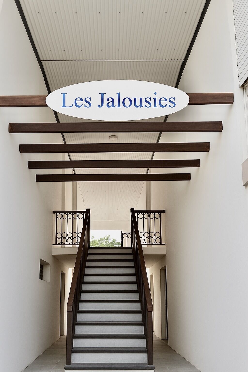 A staircase with a wooden handrail and a white ceiling.