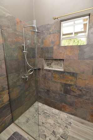 A shower with a glass door and a stone wall. - Lovely 1-bedroom apartment with King bed and AC in charming Monchy (Monchy)