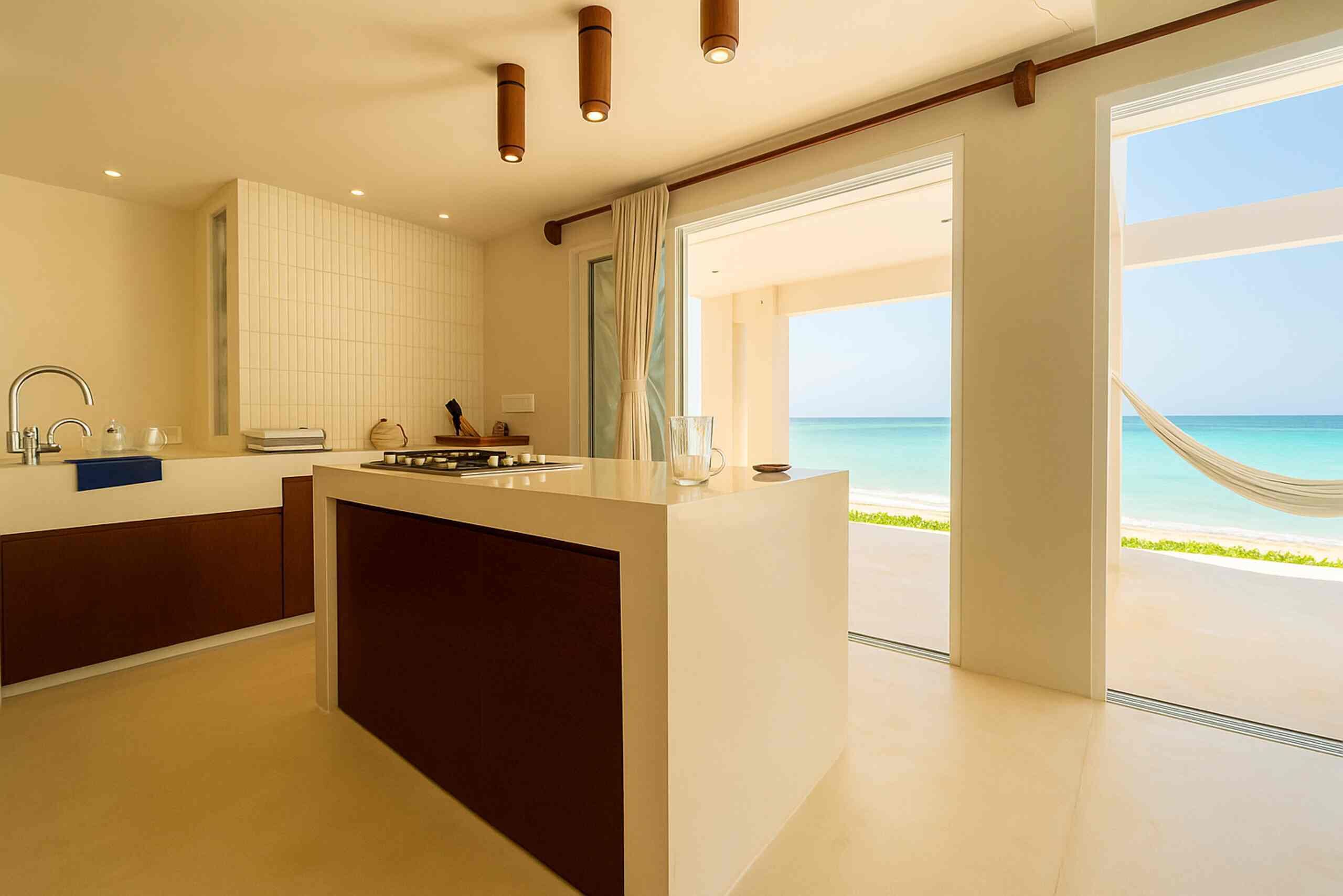 Una cocina moderna con una isla central, un ventanal y vista al mar.