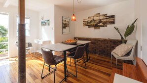 Un comedor con una mesa de madera, sillas y una lámpara colgante.