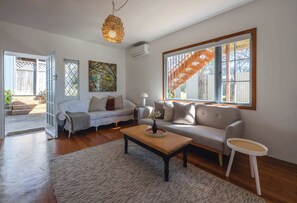 Ein modernes Wohnzimmer mit einer Couch, einem Couchtisch und Kunstwerken.