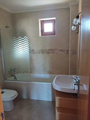 Ein Badezimmer mit Dusche, Toilette und Waschbecken.