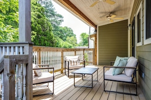 A wooden deck with outdoor furniture, including a sofa and chairs, and a ceiling fan. - Newly renovated 3/2 in the middle of town (Jonesboro)